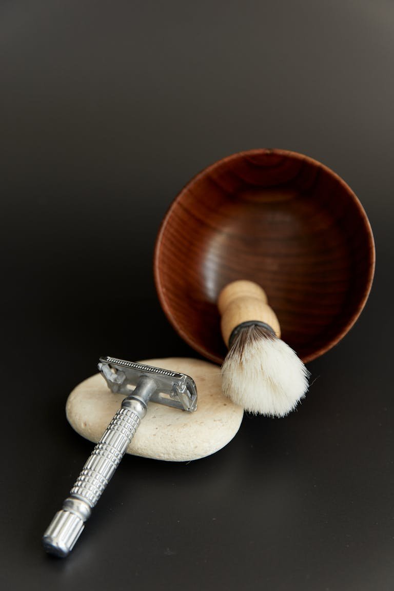 Elegant traditional shaving kit including a razor and brush on a black background.