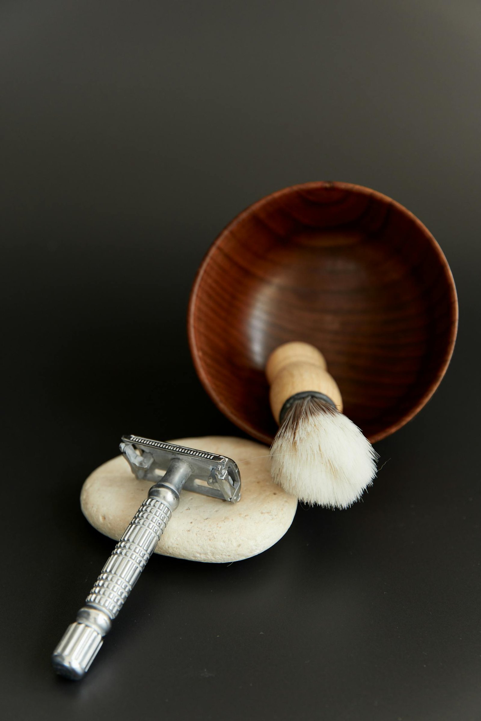 Elegant traditional shaving kit including a razor and brush on a black background.